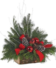 a christmas arrangement with pine cones and red ribbon in a wooden box on white background