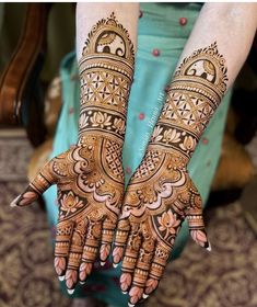 two hands with henna tattoos on them