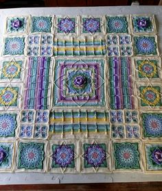 a crocheted table cloth with squares and flowers on it