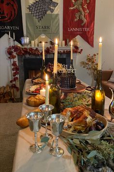 a table is set with food and candles for a thanksgiving dinner in front of the fireplace