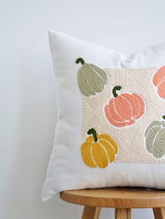 a white pillow with pumpkins on it