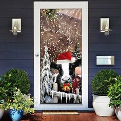 a cow wearing a santa hat standing in front of a door decorated with christmas decorations