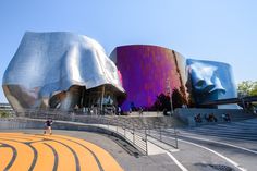 people are walking around in front of an artistic building