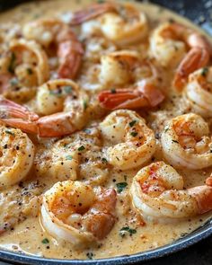 a pan filled with shrimp and sauce on top of a table