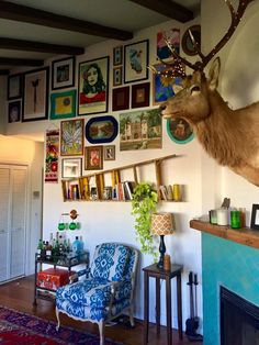 a deer head mounted on the wall above a fireplace in a living room filled with furniture