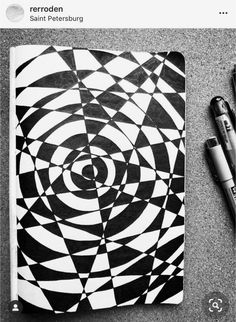 a black and white spiral notebook next to a pen