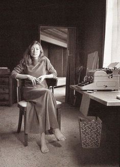 a woman sitting in a chair next to a desk