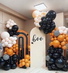 an entrance decorated with balloons and black and white decorations