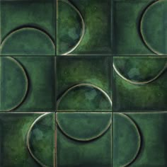 a green tiled wall with circles and rings on it's surface, as well as an image of the moon in the center