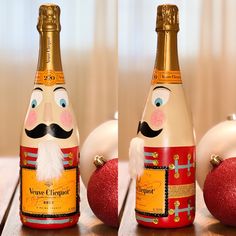 two bottles of champagne with faces painted on them, one has a mustache and the other has an ornament