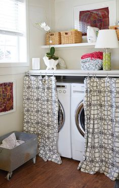 a washer and dryer sitting in a room next to a window with curtains