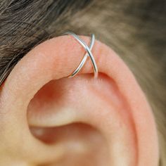 a close up of a person's ear with a silver ring on top of it