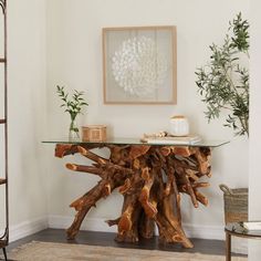 a table made out of tree trunks in a living room with potted plants on top