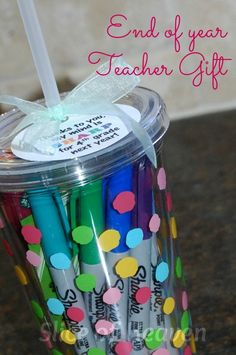 a cup filled with lots of colorful pens and writing on top of it's lid