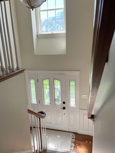 the stairs lead up to an entryway with two windows and a light fixture above them