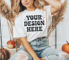 Showcase your seasonal designs with this chic white t-shirt mockup, ideal for fall and autumn fashion. This high-quality digital download depicts a beautiful woman seated in a pleasant interior environment surrounded by pumpkins and rustic decor, making it great for showcasing your seasonal clothing ideas. The mockup offers a warm and inviting background that matches your designs, making it ideal for casual and fashionable clothes. This adaptable mockup is ideal for designers who want to make a White Branded Tops For Fall, White Custom Print Shirt For Fall, Tee Shirt Mockup, Interior Environment, Boho Woman, White Tee Shirt, Fall White, White Tee Shirts, Professional Presentation