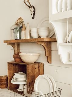 dishes are stacked on top of a wooden shelf