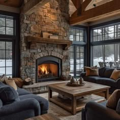 a living room filled with furniture and a fire place in front of a stone fireplace