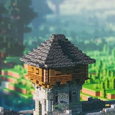 a small house made out of legos on top of a hill with trees in the background