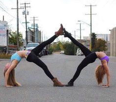 two women doing handstands in the street