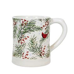 a white coffee mug with a red bird on it's side and pine branches