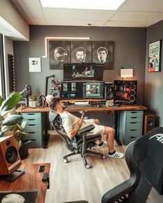 a man is sitting in an office chair with his feet up on the computer desk