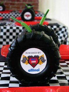 a table topped with black and white checkered tablescloths covered in monster trucks