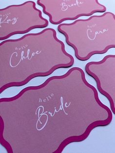 pink place cards with white writing on them