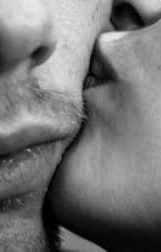 a man and woman kissing each other with their noses close to one another, black and white photograph