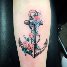 an anchor with flowers on the side of its arm is seen in this tattoo design