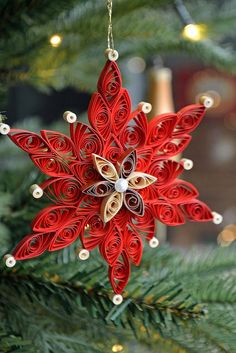 a red ornament hanging from a christmas tree