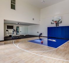 an indoor basketball court with blue and white paint on the floor is pictured in this image