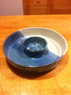 a blue and white bowl sitting on top of a wooden table