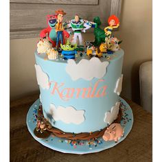 there is a blue cake with cartoon characters on it and the name karnila