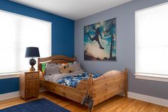 a bedroom with blue walls and wooden floors