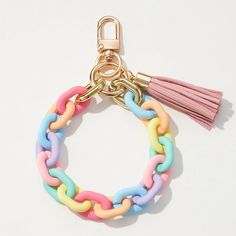 a multicolored bracelet with tassels and a keychain on a white background