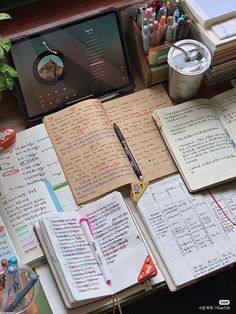 an open notebook sitting on top of a desk next to a laptop computer