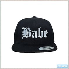 "◄ DESCRIPTION ► Old English \"Babe\" embroidered in our Super White thread color on a Black hat. Customize your own! ◄ PRODUCT . INFORMATION ► - Product Material: 80% Acrylic / 20% Wool - Product Size: Adjustable (Please refer to the Size Chart shown in the images on this page for additional information) - Panels: 6 - Structure: Structured - Profile: High - Closure: Snapback - Original Product Color(s): Black - Original Thread (Embroidery) Color(s): Super White - Logo Size: W: 4.50\" H: 1.85\" Hip Hop Hat With Embroidered Logo And Curved Brim, Embroidered Curved Brim Baseball Cap For Streetwear, Hip Hop Hat With Embroidered Logo And Flat Bill, Embroidered Trucker Hat With Flat Bill For Streetwear, Embroidered Snapback Hat With Flat Brim For Streetwear, Embroidered Snapback Dad Hat For Streetwear, Embroidered Adjustable Snapback Hat For Streetwear, Adjustable Embroidered Snapback Hat For Streetwear, Embroidered Flat Bill Trucker Hat For Streetwear