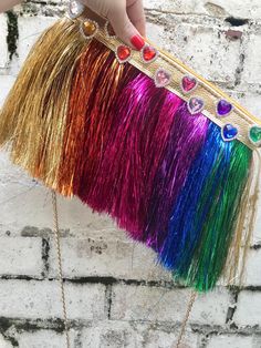 Rainbow tinsel bag  ❤️ The base of the bag is made from metallic faux leather fabric. Choose the colour you would like for the base of the bag and the strip of fabric at the top of the bag, from the drop down list. 🧡Bag is embellished with different colours of tinsel fringe trim. The front and back of the bag are the same. 💛 It is embellished with heart jewels along the top of the bag, in different colours  💚 The bag is lined with coordinating lining and has a coordinating coloured zip along Gold Fringe Party Bag, Gold Fringe Rectangular Bag, Gold Rectangular Bag With Fringe, Rainbow Rectangular Bag For Parties, Iridescent Rectangular Shoulder Bag For Party, Rainbow Rectangular Party Bag, Embellished Bags, Faux Leather Fabric, Fringe Trim