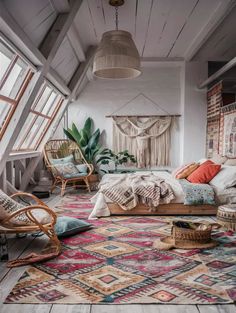 an attic bedroom with white walls and wooden floors, colorful rugs on the floor