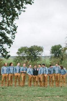 a group of men standing next to each other on top of a lush green field