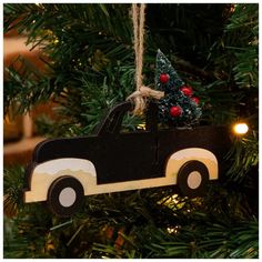 a christmas tree ornament with a black truck and a small pine tree in the back