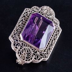 Vintage 1920's 14k White Gold Amethyst Solitaire Brooch Pendant Combo 17.25ctWorn on hats, jacket lapels or on the hip and with sleeveless outfits, this vintage 1920's 14k white gold amethyst brooch added color and class to any outfit back then. With a beautifully cut amethyst and fine filigree surrounding the stone, this brooch is a truly stunning piece, showing us what was popular in the 1920's. Metal Information: 14k White Gold Total Weight: 8.7g Width: 24 MM Length: 39.6 MM Circa: 1920's Sto Elegant Purple Gemstone Brooches, Luxury Purple Brooches For Formal Occasion, Elegant Amethyst Brooches For Wedding, Vintage Gemstone Brooches For Formal Occasions, Purple Brooch Jewelry For Evening, Elegant Purple Brooches For Anniversary, Antique Purple Brooches For Formal Occasions, Antique Purple Formal Brooches, Heirloom Filigree Brooches For Formal Occasions