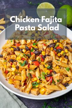 chicken fajita pasta salad in a white bowl with limes on the side