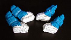 four crocheted blue and white shoes on a black surface