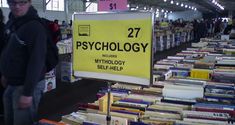 a man standing in front of a display of books at a book sale with a sign that says, psychic