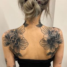 a woman with tattoos on her back and shoulder