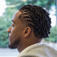 a man with dreadlocks looking out the window