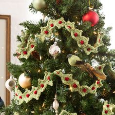 a crocheted christmas tree with ornaments on it