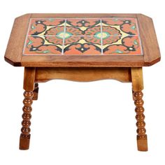 a small wooden table with colorful tile on it